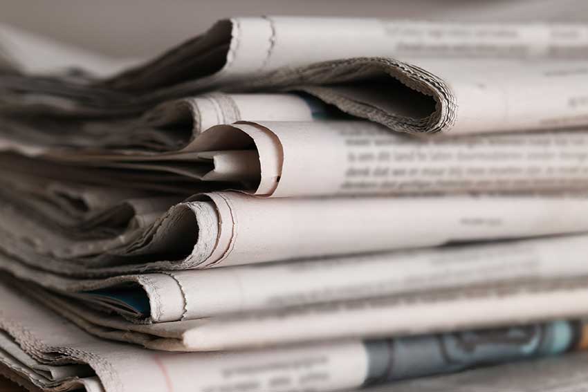 Many newspapers in different languages as background, closeup