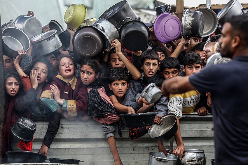 Displaced Palestinians in Al-Mawasi crowd to get rice meals from (Al-Takiya) due to the lack of flour and also the lack of entry of aid, in the southern Gaza Strip, on November 29, 2024.
