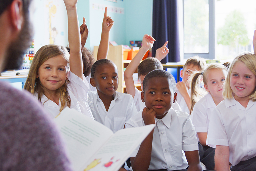 A generic image of a man reading to school children.